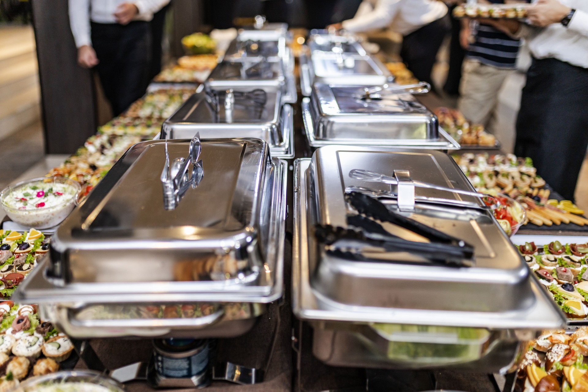 Elegant buffet setup with a variety of dishes at a social event in an upscale venue during the evening